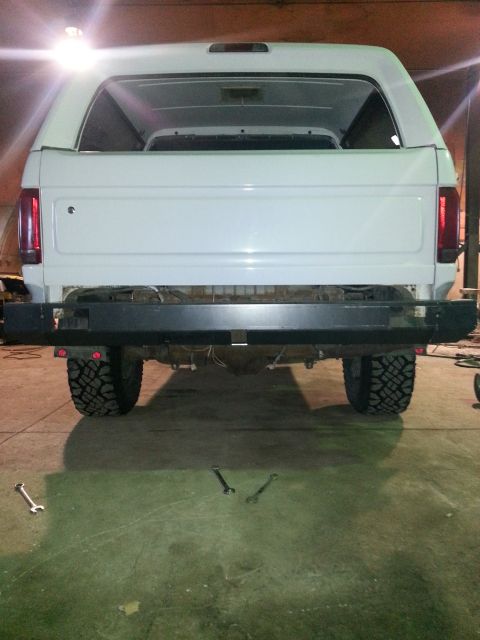 1994 Ford Bronco - Rear view of a white SUV with an aftermarket bumper and off-road tires.