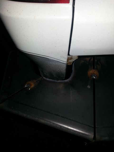 1994 Ford Bronco - Close-up view of the rear bumper corner on a white 1994 Ford Bronco, showing the black trim and body panel.
