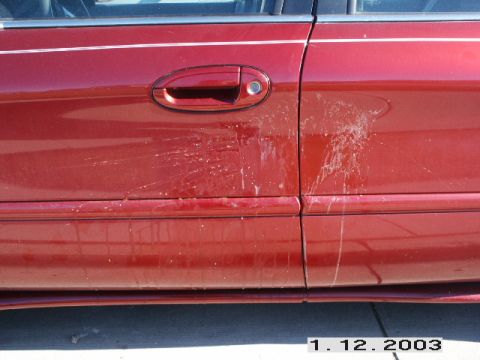 1998 Mercury Sable - The side of a red 1998 Mercury Sable shows a pinstripe and significant bird droppings on the door panel.