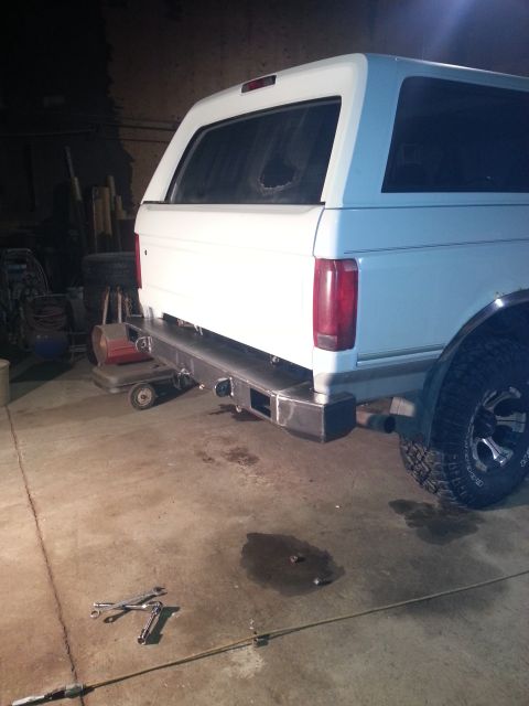 1994 Ford Bronco - The rear of a white SUV is shown with a custom-fabricated bumper, suggesting recent modifications or repairs.