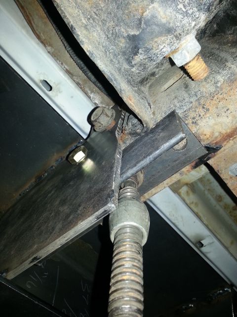 1994 Ford Bronco - Close-up view of a vehicle's undercarriage, showing rust and a mechanical jack.