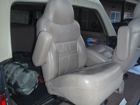 1994 Ford Bronco - Tan leather seats and a sleeping bag are visible inside the 1994 Ford Bronco.