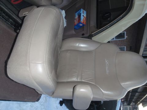 1994 Ford Bronco - The interior of a vehicle shows a tan leather driver's seat with 'Limited' stitched on the side.