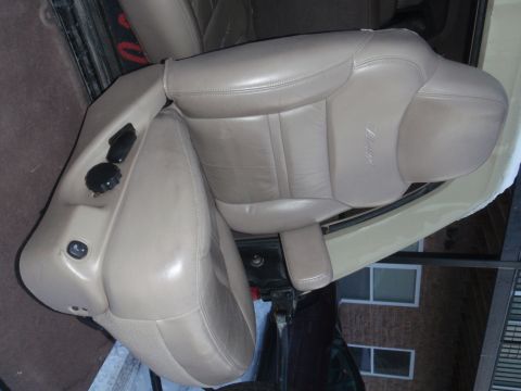 1994 Ford Bronco - Interior view of tan leather seats, likely from an SUV, with embossed 'Eddie Bauer' script visible.
