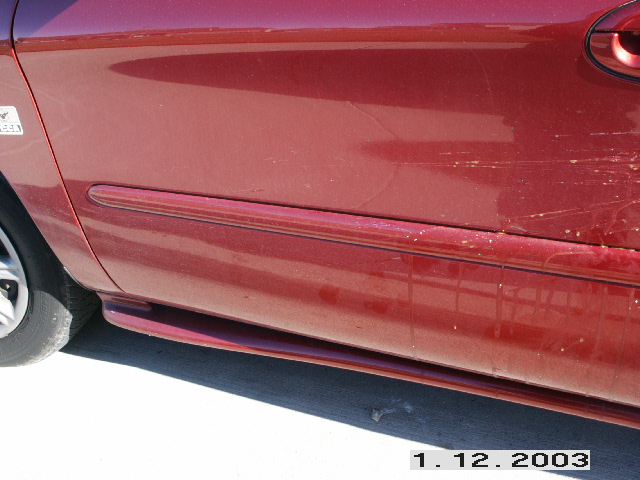 Red 1998 Mercury Sable side view showing door trim and scratches