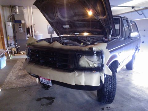 1992 Ford Bronco - The front end of a Ford Bronco is prepped for paintwork in a garage setting.