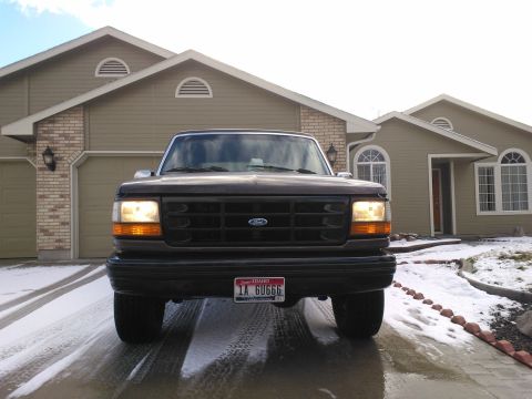 1992 Ford Bronco - This Ford F-150 truck, likely from the early to mid-1990s, is parked in front of a suburban house.
