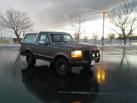 1992 Ford Bronco - 1992 Ford Bronco with a bull bar and auxiliary lights parked outside on a wet day.