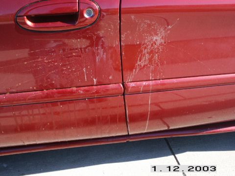 1998 Mercury Sable - Close-up of bird droppings on a red car door and fender.