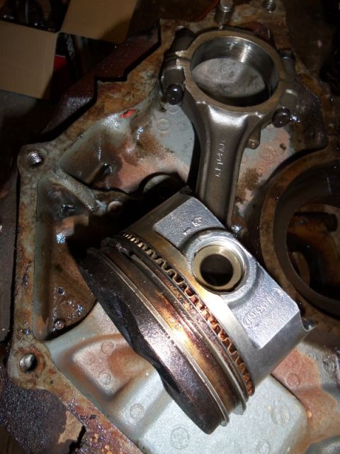 1989 Ford Bronco - Close-up of internal engine components, including a piston and connecting rod, in a disassembled state.