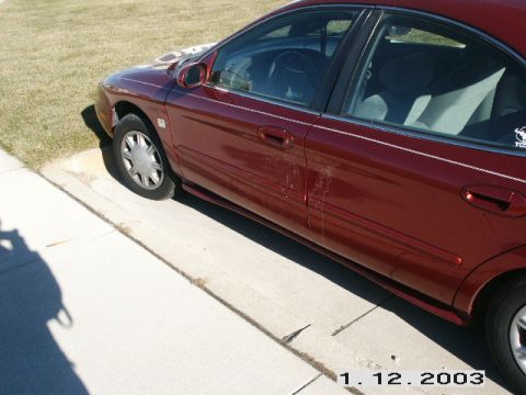 1998 Mercury Sable - A side view of a maroon sedan parked on a sunny day.