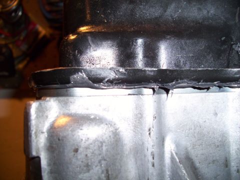 1995 Ford Probe - Close-up of a mechanical part showing a poorly applied gasket seal.