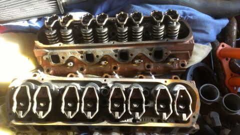 1990 Ford Bronco - Close-up view of disassembled engine cylinder heads, showing internal components like valves and springs.