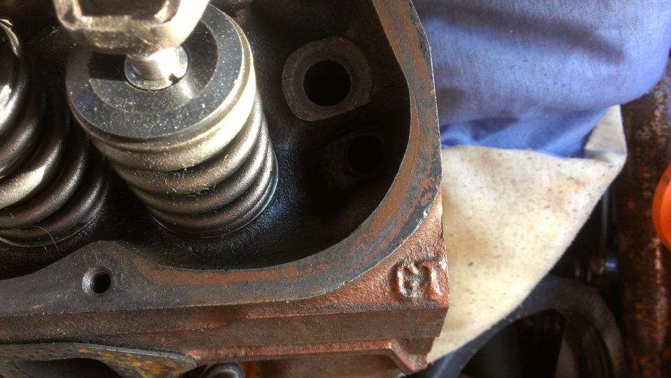 Close-up of engine cylinder head with valve springs and a GT marking