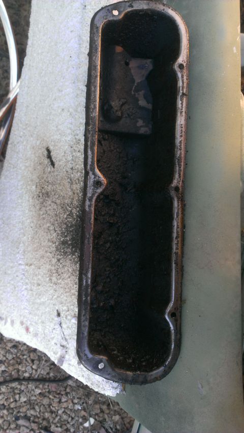 1990 Ford Bronco - This is a dirty valve cover, likely from an engine, with significant sludge buildup.