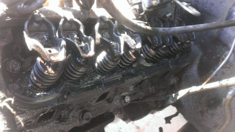 1990 Ford Bronco - The image shows the internal components of an engine, specifically the valve train, covered in oil.