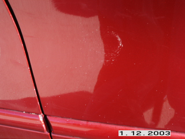 Red car door seam with minor paint imperfections