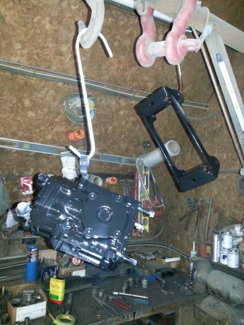 1994 Ford Bronco - Workshop scene with a painted automotive component suspended for drying.