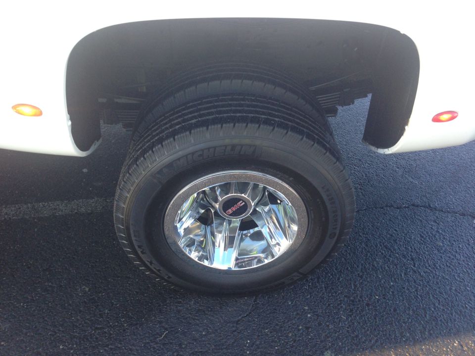 White dually truck rear wheel with chrome GMC center cap and Michelin tires
