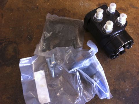 1987 Suzuki Samurai - A black steering gearbox and associated hardware are laid out on a wooden surface.