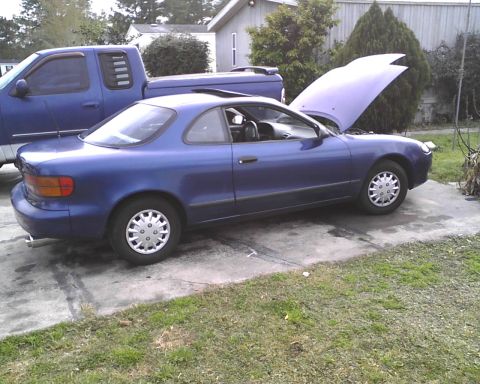 1991 Toyota Celica - A blue coupe, likely a 1993 model, is parked with its hood open next to a blue pickup truck.
