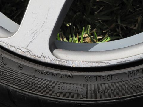 1995 Ford Bronco - Close-up of a damaged alloy wheel and tire, showing significant wear and tear on the rim.