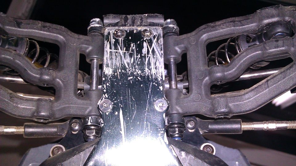 Close-up of RC car suspension with black plastic arms and metal shocks