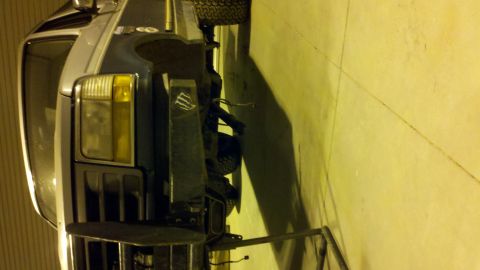 1996 Ford Bronco - The front of a blue Ford Bronco is visible, a black grille and an aftermarket bumper with a monster logo.