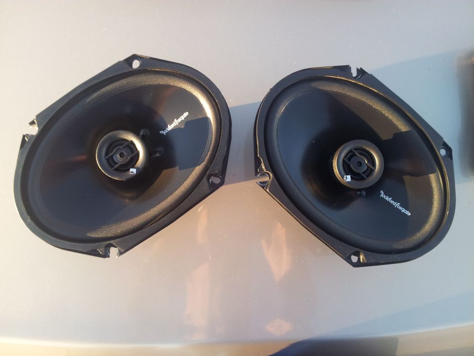 Two oval car speakers, one with Rockford Fosgate logo visible
