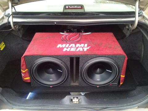 1998 Mercury Grand Marquis - The trunk of a car contains a large subwoofer box with the Miami Heat logo, and a Rockford Fosgate emblem is visible above.
