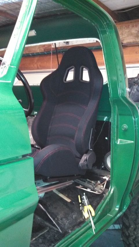 1967 Ford F-250 - Aftermarket racing seat installed in the cab of a green truck.