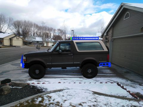 1992 Ford Bronco - This Ford Bronco is parked in a residential driveway during winter, custom blue exterior accessories.