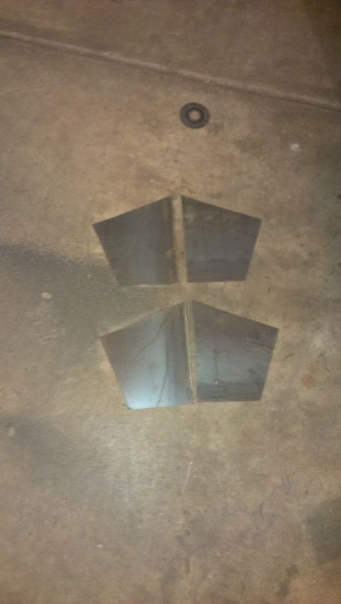 1995 Ford Bronco - Four metal pieces, possibly for a bumper build, lie on a concrete floor.