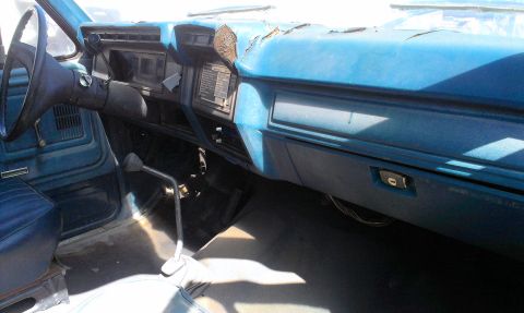 1994 Ford Bronco - Interior view of a worn dashboard and driver's seat in an older truck.