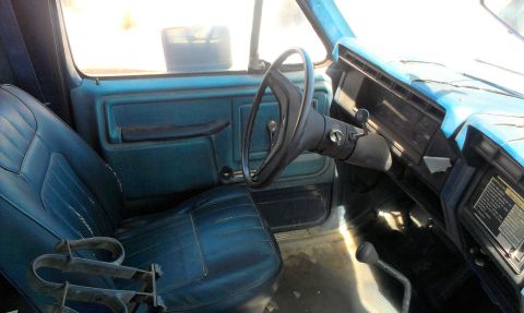 1994 Ford Bronco - Interior view of a blue truck, showing the driver's seat, steering wheel, and dashboard.