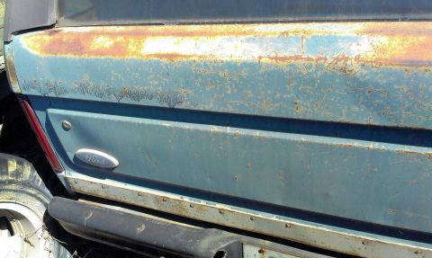 1994 Ford Bronco - This blue Ford Bronco shows significant rust and faded "US AIR FORCE" lettering on its rear quarter panel.