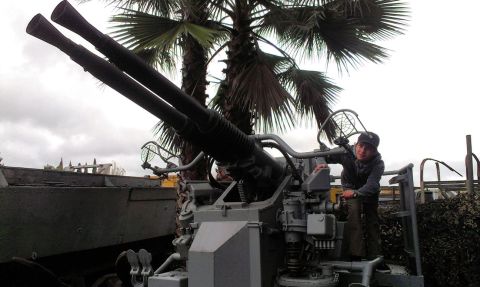 1994 Ford Bronco - A person poses with a large caliber anti-aircraft gun, possibly at a museum or historical site.