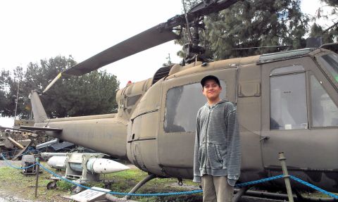1994 Ford Bronco - A young person poses for a photo next to a military helicopter on display.