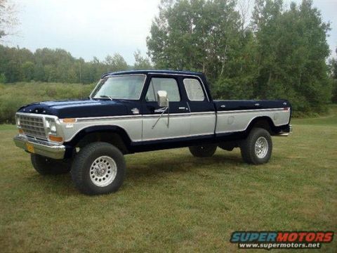 1994 Ford Bronco - This lifted Ford pickup truck features a two-tone blue and silver paint scheme and prominent chrome trim.