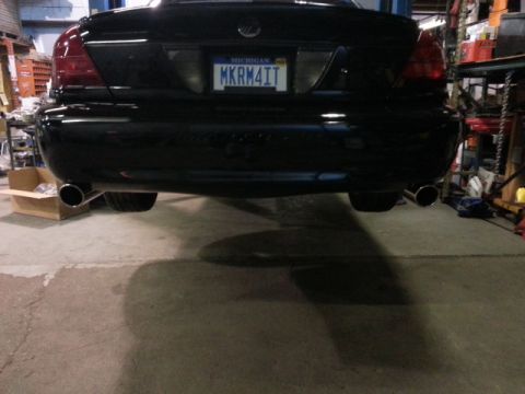2004 Mercury Grand Marquis - Rear view of a black 2004 Mercury Grand Marquis, dual exhaust pipes and a Michigan license plate.