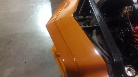 1973 Chevrolet Camaro - Close-up view of an orange car's fender and engine bay, with the Supermotors logo visible in the lower right corner.