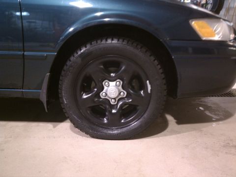 1998 Toyota Camry - Close-up of the front wheel and fender area of a 1998 Toyota Camry.