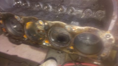 1990 Ford Bronco - Engine cylinder head showing signs of wear and tear, with rust and carbon deposits.