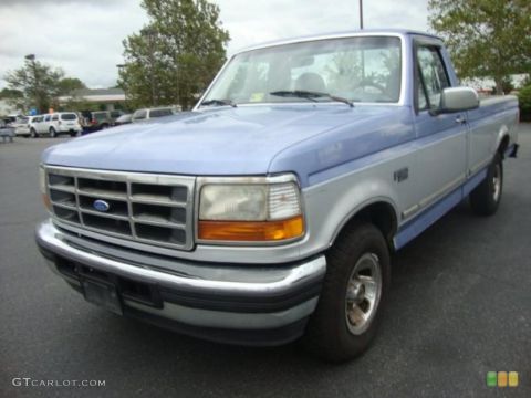 1992 Ford Bronco - A two-tone blue and silver Ford F-150 pickup truck is parked outdoors on a cloudy day.