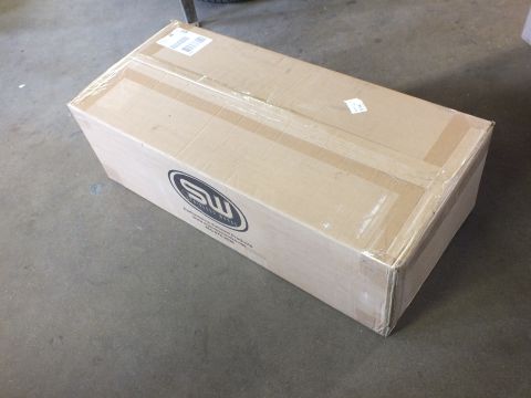 2003 Ford Crown Victoria - upright taped cardboard shipping box marked with an MS oval logo sits on a concrete surface.