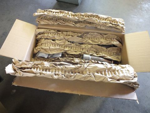 2003 Ford Crown Victoria - Long shipping box opened to reveal stainless tubing and packaging materials inside.