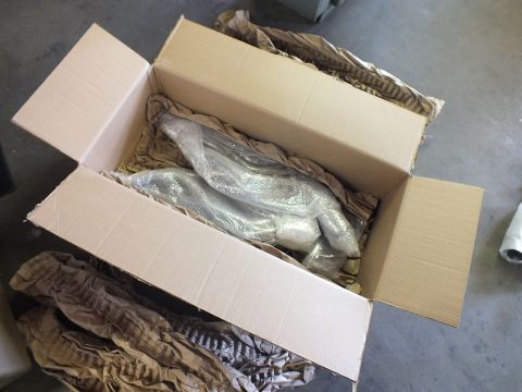 2003 Ford Crown Victoria - Open box revealing two bubble-wrapped header assemblies surrounded by kraft paper fill.