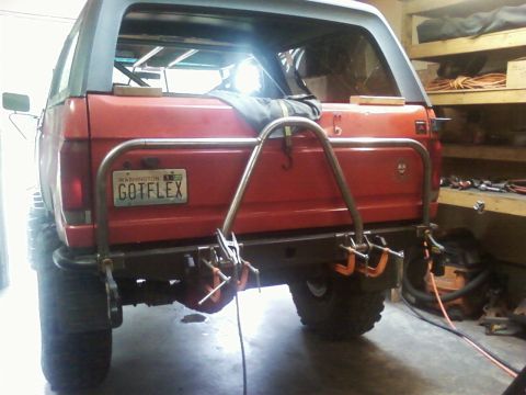 1989 Ford Bronco - Custom rear bumper and tire carrier assembly on a red SUV.