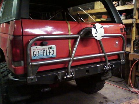 1989 Ford Bronco - Rear view of a red 1989 Ford Bronco a custom tube bumper and swing-down tire carrier.