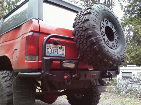 1989 Ford Bronco - Rear view of a red 1989 Ford Bronco showing its spare tire carrier and custom license plate.